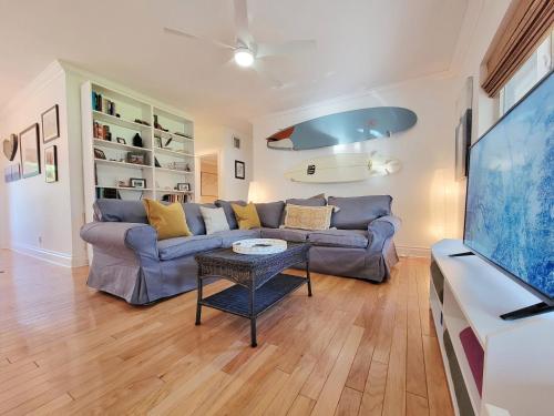 The Surf House في فورت لاودردال: غرفة معيشة مع أريكة وطاولة