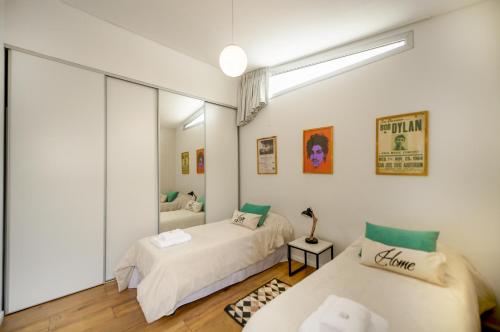 1 dormitorio con 2 camas y espejo en Fliphaus Honduras 5750 - Lux 3 Bd Palermo H en Buenos Aires
