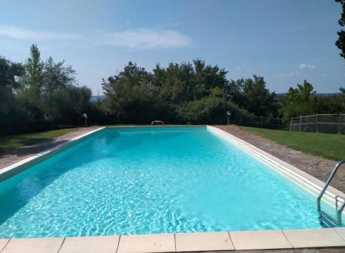 a swimming pool with blue water in a yard at Villa Poggio al Sole Bio Agriturismo private pool in San Rocco a Pilli
