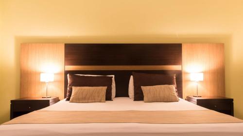1 dormitorio con 1 cama grande y 2 lámparas en Pirayu Hotel & Resort en Puerto Iguazú