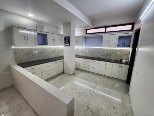un ampio bagno con armadi bianchi e pavimenti in marmo di EL Dorado 11 a Indore