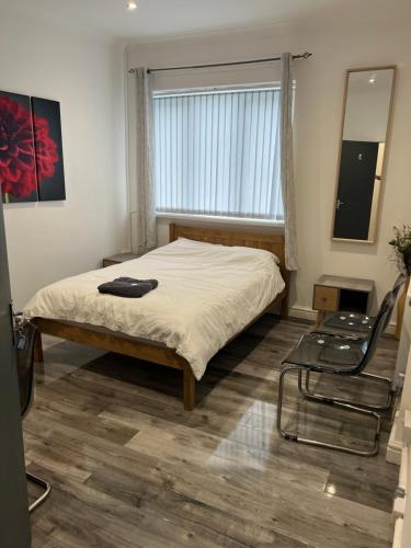 a bedroom with a bed and a window and a chair at Zams rooms in Stoke on Trent