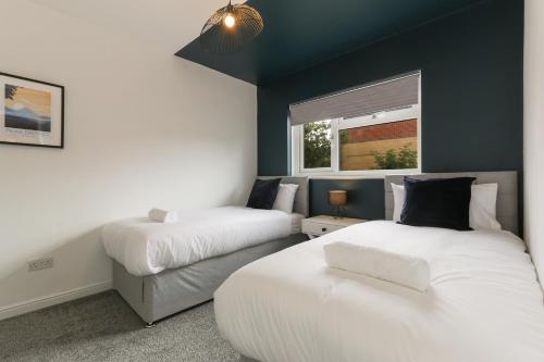 a bedroom with two beds and a window at City Oaks - Sheffield Station & Utilita Arena in Sheffield