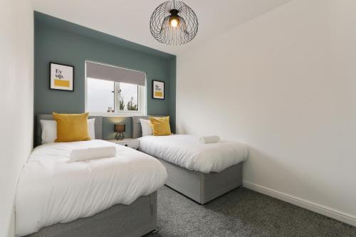 a bedroom with two beds and a chandelier at City Oaks - Sheffield Station & Utilita Arena in Sheffield