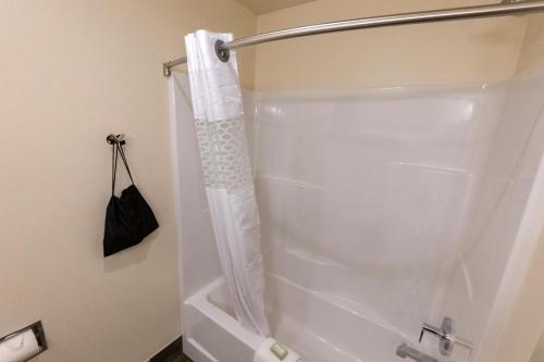 y baño con ducha con cortina blanca. en Cobblestone Hotel & Suites-Sheldon, en Sheldon