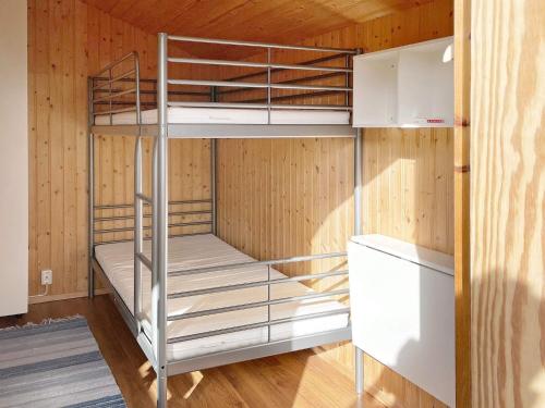 Łóżko piętrowe w pokoju z drewnianymi ścianami w obiekcie Holiday home BROMÖLLA w mieście Bromölla