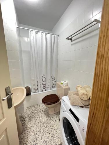 une salle de bains blanche pourvue d'un lave-linge. dans l'établissement VV_InfiniteViews, à Bajamar