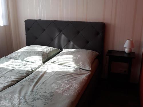 a bed with a black headboard and a side table at Apartment, Altdöbern in Altdöbern