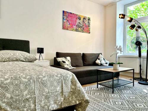 een slaapkamer met een bed en een bank bij Modern Stylish Studio near Center in Wenen
