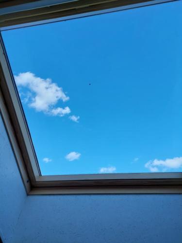 una ventana en una habitación con un cielo azul en Vasaknų dvaras, en Žabičiūnai