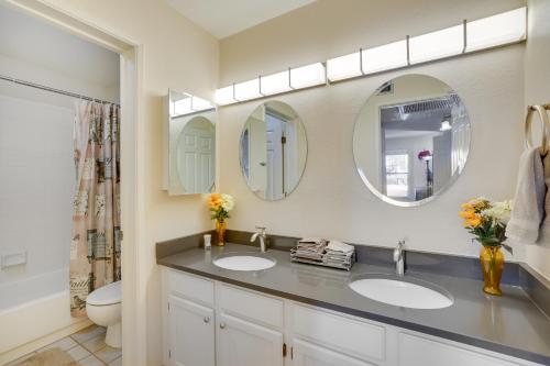 a bathroom with two sinks and two mirrors at Tucson Oasis Heated Pool, Tennis Court, Hiking! in Tucson