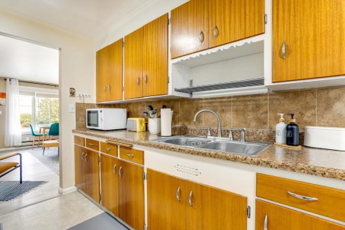 a kitchen with wooden cabinets and a sink at Scandi Boho Seattle Apartment, Walk to Waterfront! in Seattle