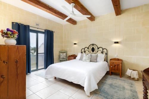 una camera da letto con un letto e un ventilatore a soffitto di Dar ta' Censina Villa with Private Pool a Għasri