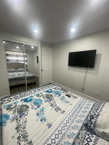 a bedroom with a bed with a television on the wall at Mo's Place in Mississauga
