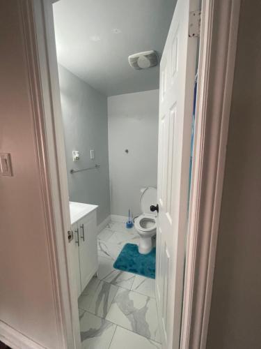 ein Badezimmer mit einem WC und einem blauen Teppich in der Unterkunft Mo's Place in Mississauga