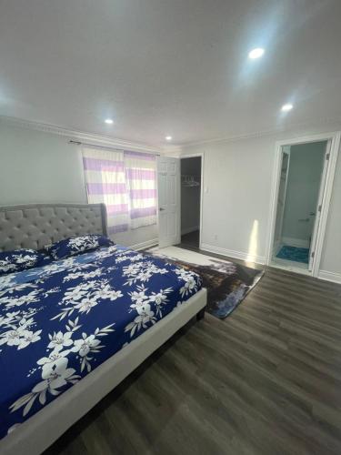 a bedroom with a bed with a blue and white blanket at Mo's Place in Mississauga