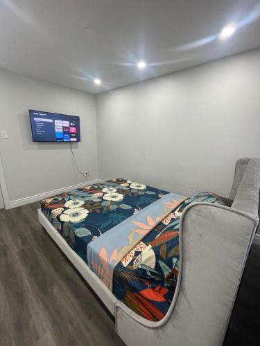Bett in einem Zimmer mit einem TV an der Wand in der Unterkunft Mo's Place in Mississauga