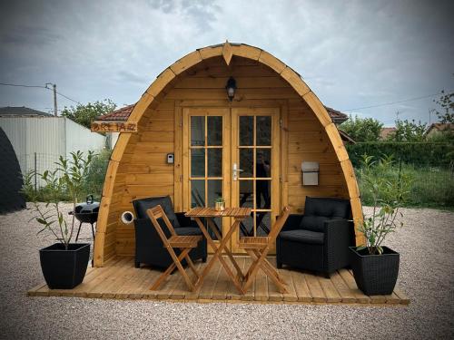 a small wooden cabin with a table and chairs at Les Chalets du Parc in Saint-Eulien