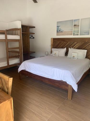 1 dormitorio con 1 cama grande con sábanas blancas en Hotel El Quemaito - Luxury Oceanfront Retreat, en Santa Cruz de Barahona