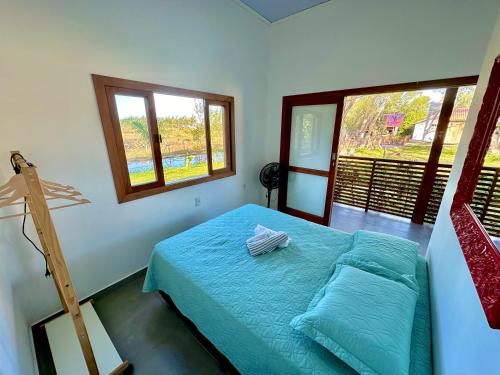 a bedroom with a bed with a ladder and two windows at Mangue Seco, 120 metros do mar e 100 metros das dunas. in Jaguaruna