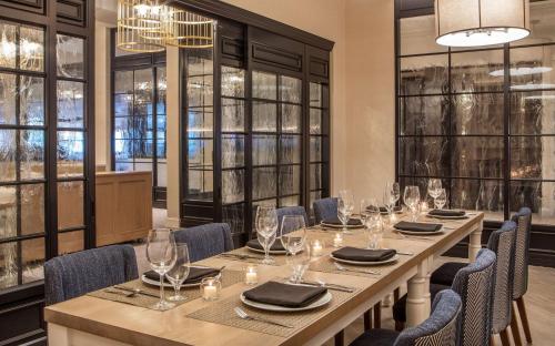 a dining room with a long table with chairs and windows at Hilton Wilmington/Christiana in Newark