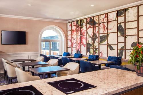 a restaurant with tables and chairs and a window at Hilton Wilmington/Christiana in Newark