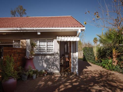 a white house with a red roof at Die Moerbeiboom in Bloemfontein