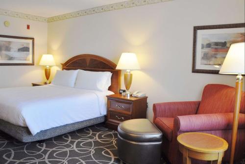 Habitación de hotel con cama y silla en Hilton Garden Inn Gettysburg, en Gettysburg