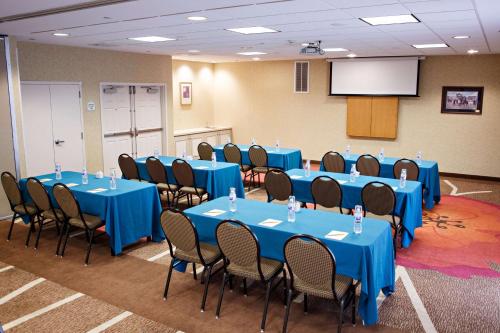 a conference room with blue tables and chairs and a screen at Hilton Garden Inn Gettysburg in Gettysburg