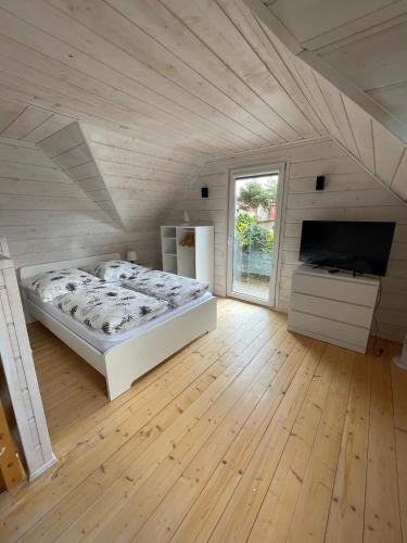 a large bedroom with a bed and a television at Lilly 5 Stars in Grzybowo
