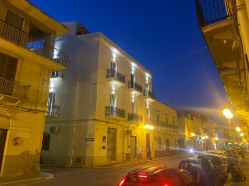 een stadsstraat 's nachts met auto's geparkeerd voor gebouwen bij SERENA PALACE SUPERIOR ROOMS in Mazara del Vallo
