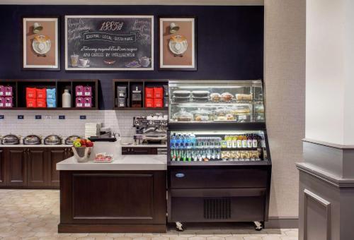 a coffee shop with a counter and a refrigerator at Hilton Richmond Downtown in Richmond
