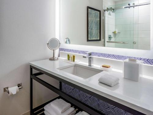 a bathroom with a sink and a mirror at Hilton Richmond Downtown in Richmond