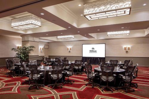 a conference room with tables and chairs and a screen at Hilton Richmond Downtown in Richmond