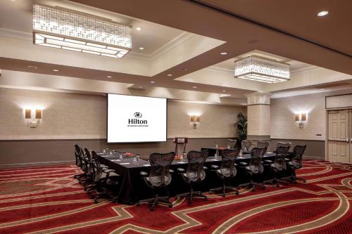 a conference room with a table and chairs and a screen at Hilton Richmond Downtown in Richmond