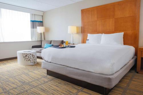 a hotel room with a large bed and a couch at DoubleTree by Hilton Rochester in Henrietta