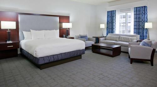 Hilton Scranton & Conference Center في سكرانتون: فندق كبير غرفه بسرير واريكه