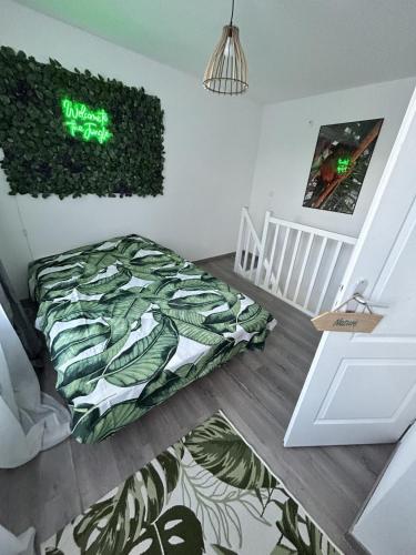 ein Schlafzimmer mit einem Bett und einer grünen Wand in der Unterkunft Les Jardins Tropicaux Duplex in Boulay - Moselle