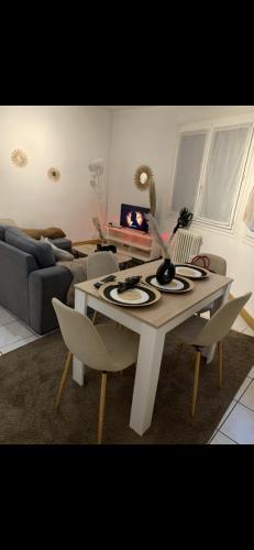 a living room with a table and chairs and a couch at Apartement centre ville in Nîmes