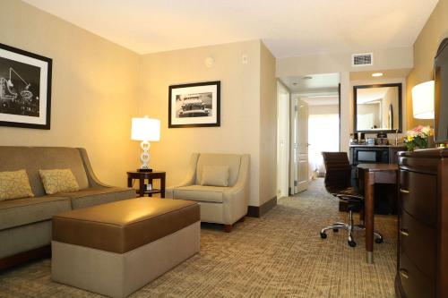 a living room with a couch and a chair and a desk at Embassy Suites Nashville - at Vanderbilt in Nashville