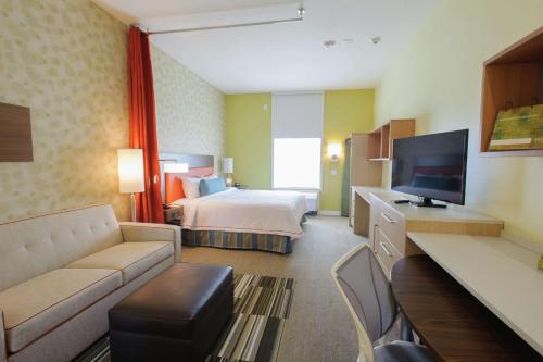 a hotel room with a bed and a television at Home2 Suites by Hilton Portland in Portland