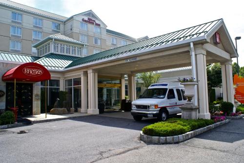 una furgoneta blanca estacionada frente a un edificio en Hilton Garden Inn New York/Staten Island, en Staten Island