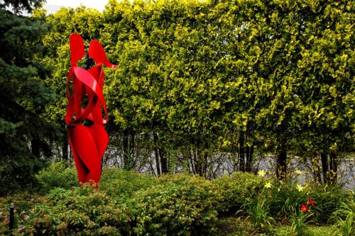 una escultura roja de dos pájaros sobre algunos arbustos en Hilton Garden Inn New York/Staten Island, en Staten Island