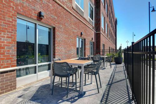 a patio with a table and chairs next to a brick building at Hampton Inn & Suites Canal Winchester Columbus in Canal Winchester