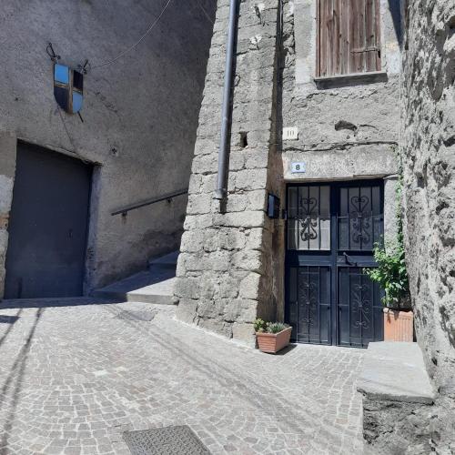 a stone building with a blue door and a doorway at La grotta in Fabrica di Roma