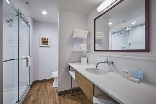 a bathroom with a sink and a toilet and a mirror at Hampton Inn & Suites Roseburg in Roseburg