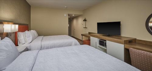 a hotel room with two beds and a flat screen tv at Hampton Inn & Suites Roseburg in Roseburg