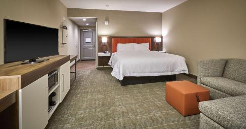 a hotel room with a bed and a flat screen tv at Hampton Inn & Suites Roseburg in Roseburg