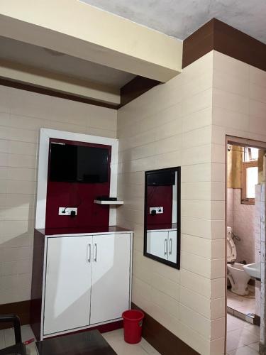 La salle de bains est pourvue d'armoires blanches et d'une télévision murale. dans l'établissement Dream Land Hotel, à Jammu