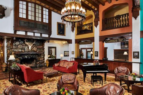 a large living room with a fireplace and a piano at Hotel Alex Johnson Rapid City, Curio Collection by Hilton in Rapid City